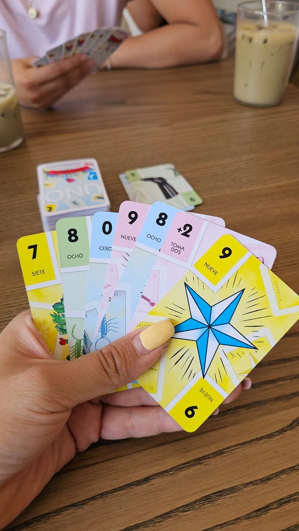 Friends play UNO Lotería at Mexican café with coffee