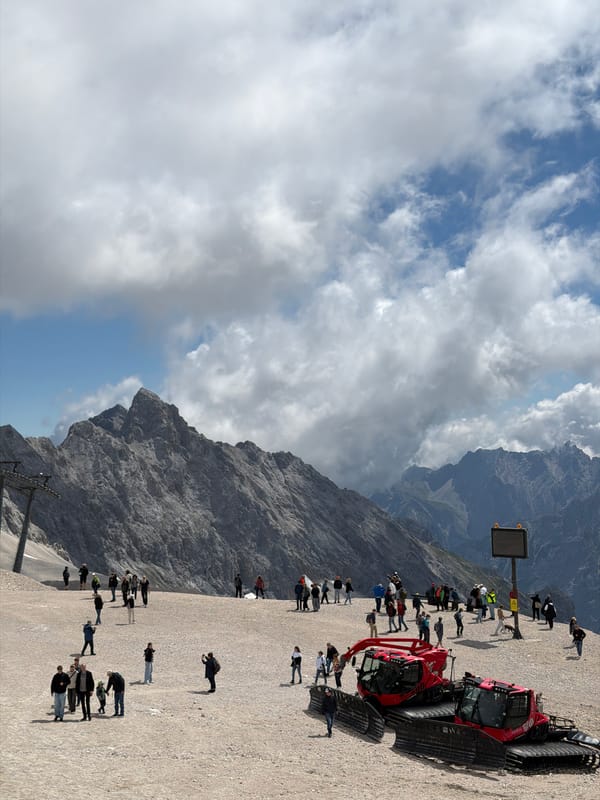 Summer morning at the Zugspitze summit, snowcats and hikers