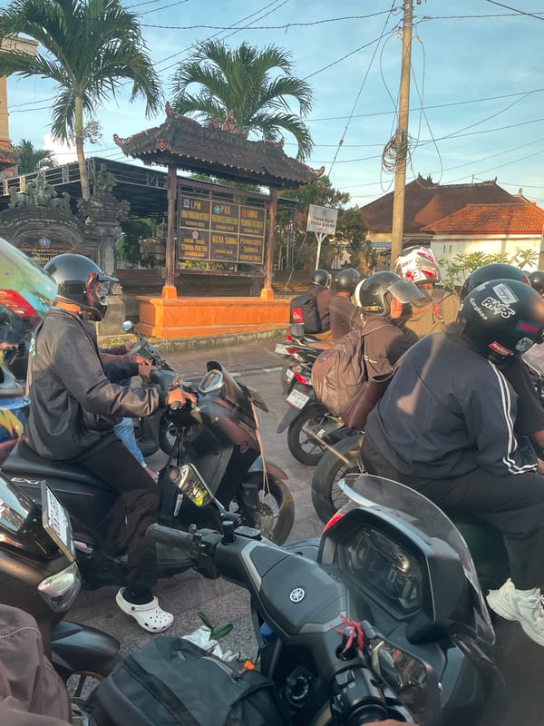 Motorcyclists wait at intersection in Mengwi, Bali