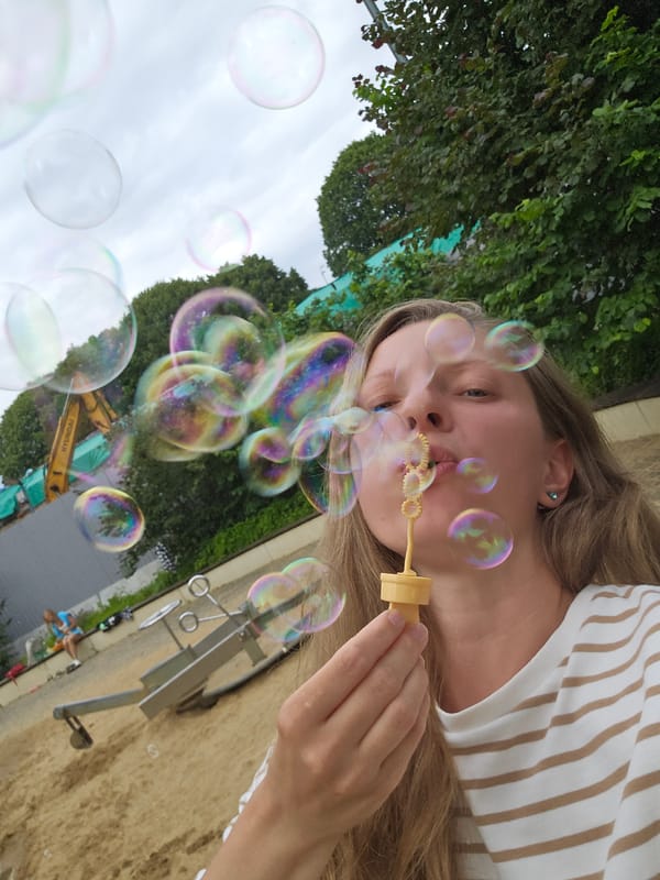 Sunny afternoon at a sandy playground — bubbles, kids, good vibes.