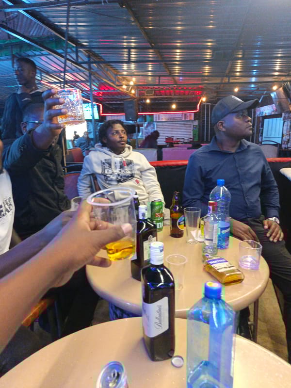 Men socialize over drinks at Nairobi bar Thursday evening