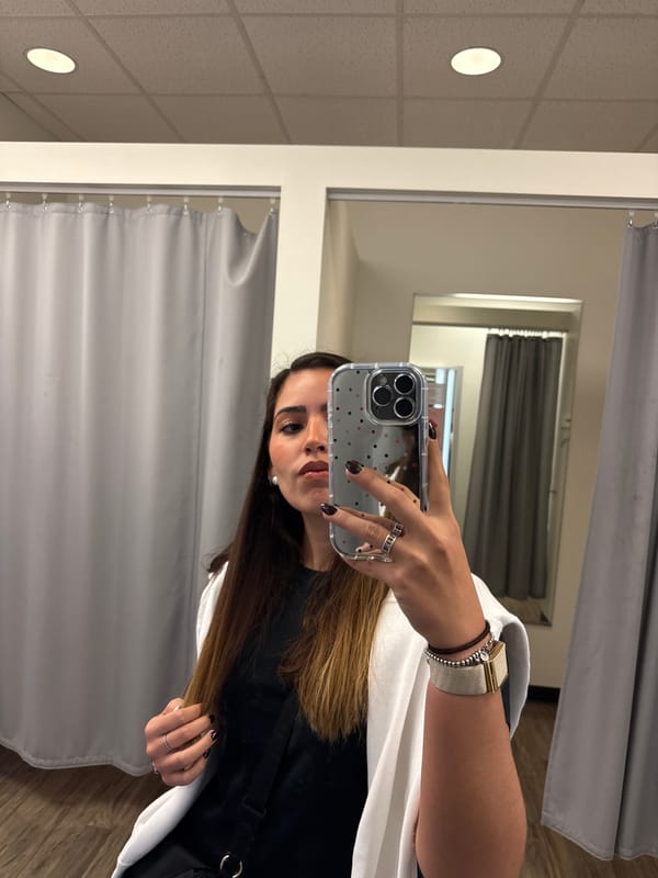 Woman takes selfies while shopping in San Marcos clothing store