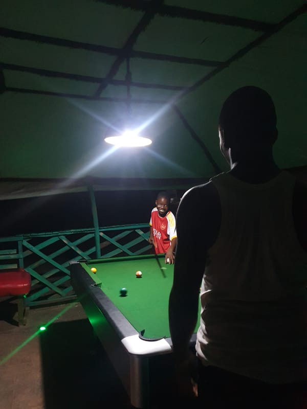 Night billiards under a green canopy in Lokoja, Nigeria
