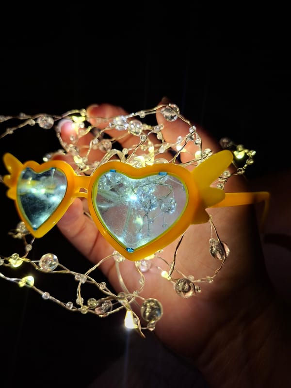 Fairy lights and heart sunglasses in a dim indoor setting
