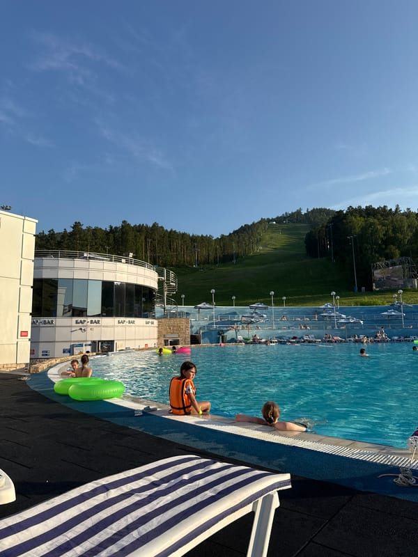Busy outdoor pool in Krasnoyarsk on a bright summer afternoon