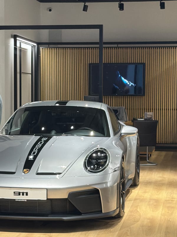 Two men view silver Porsche display in Varna showroom