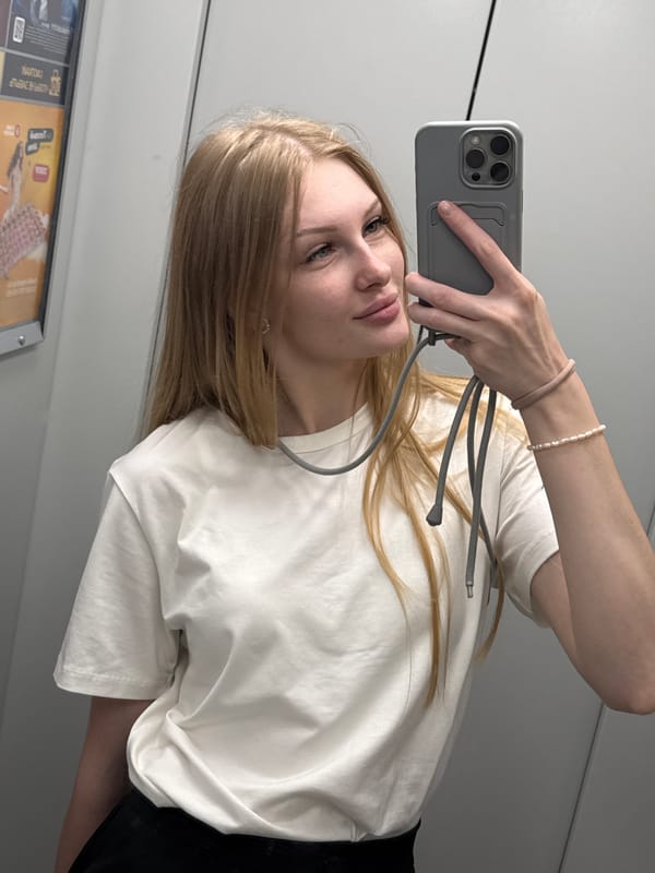 Mirror selfie in a Perm elevator, grey phone in hand.