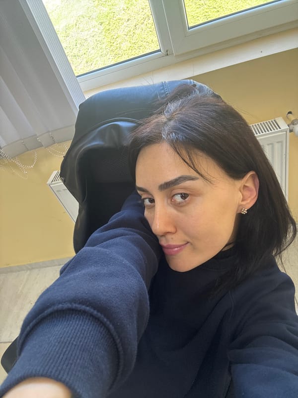 Woman rests in office chair near window in Tbilisi