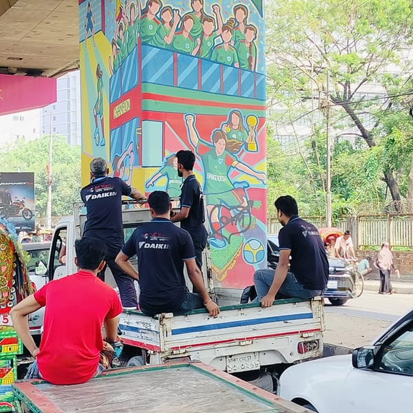DAIKIN workers transported by truck through downtown Dhaka streets