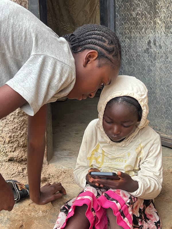 Sharing a phone screen outside in Jos, Nigeria