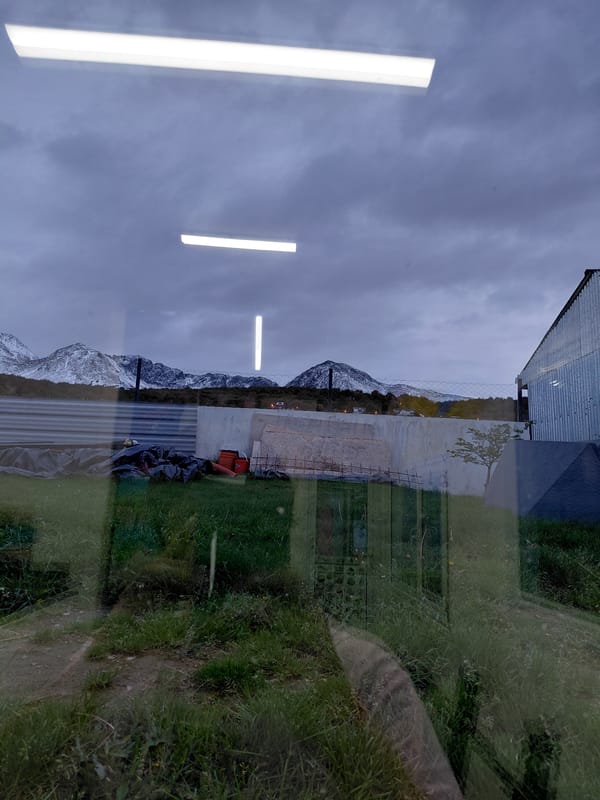 Window view captures snow-capped mountains in Ushuaia, Argentina