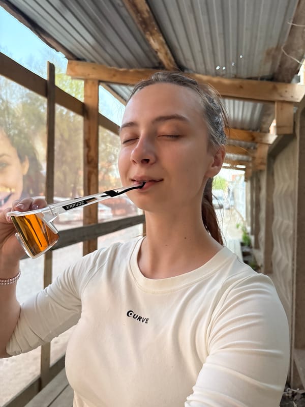 Woman holds orange sunglasses in mouth indoors in Perm