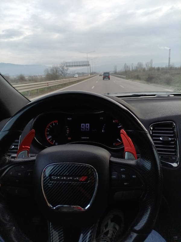 Driver travels Bulgarian highway in Dodge vehicle with sporty interior