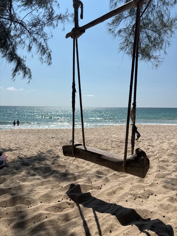 Wooden swing overlooks sandy beach in Choeng Thale, Thailand