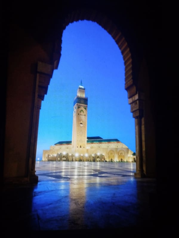 Twilight mosque illumination captured through archways in Martil, Morocco
