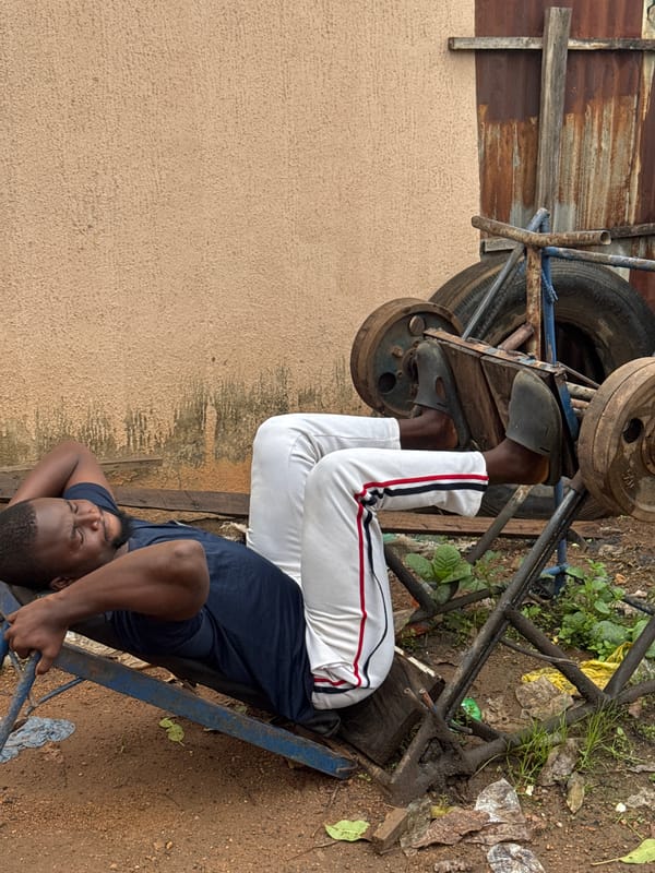 Outdoor leg press workout on a makeshift bench in Akwanga