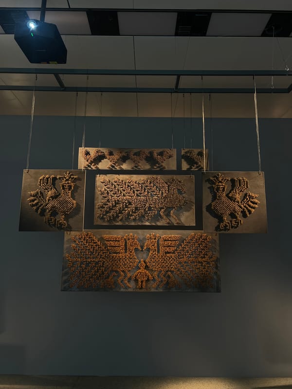 Cross-shaped art installation displayed in museum gallery ceiling