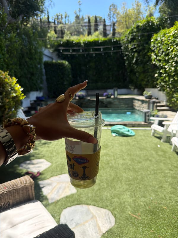 Woman takes selfie with drink in Los Angeles evening