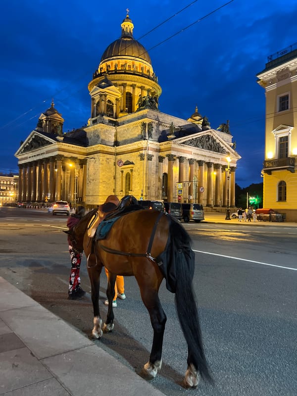St. Isaac's Cathedral at dusk, with Saint Petersburg street life nearby