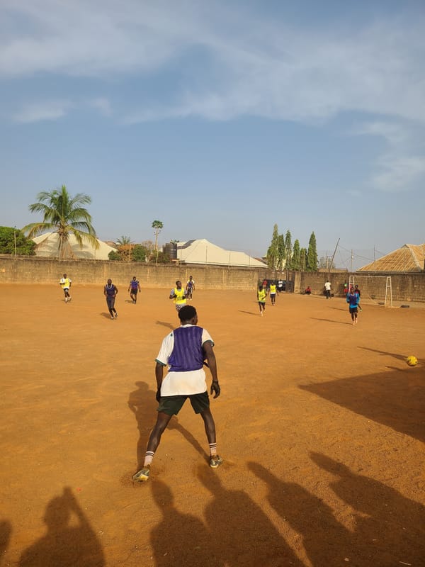 Morning soccer match played on dirt field in Nigeria