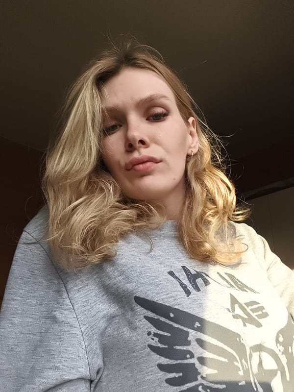 Woman in grey ALPHA sweatshirt photographed in Russian village