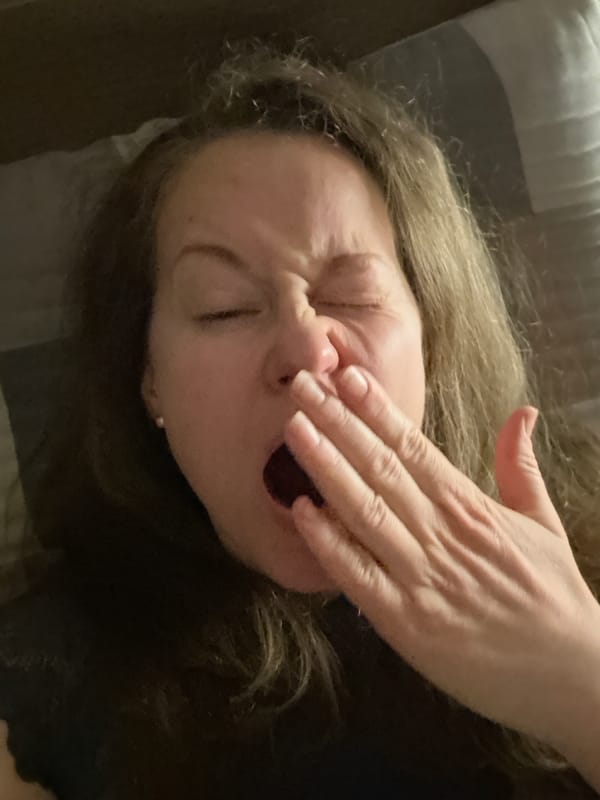 Woman captured yawning in bed during evening hours in Moscow