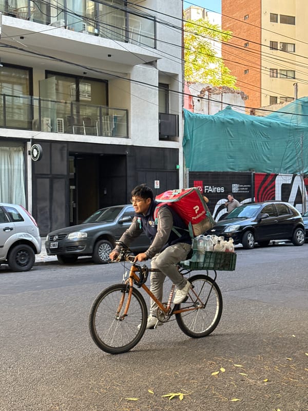 Delivery worker cycles through Buenos Aires street scene