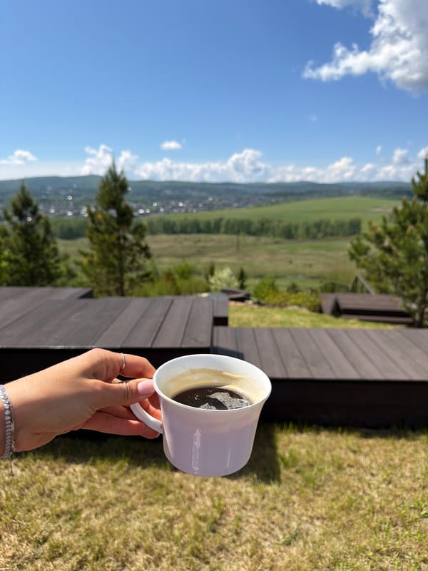 Woman enjoys morning coffee on wooden deck in Shamoni