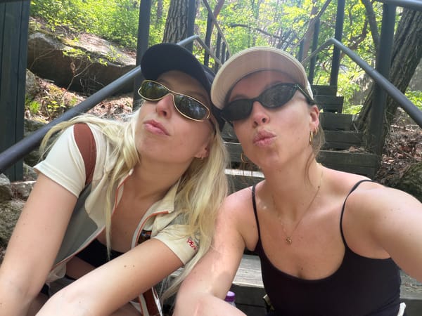 Two women take selfie on wooden stairs in Seoul