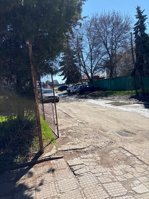 Morning street scene captured in Sofia alleyway with reflective puddle