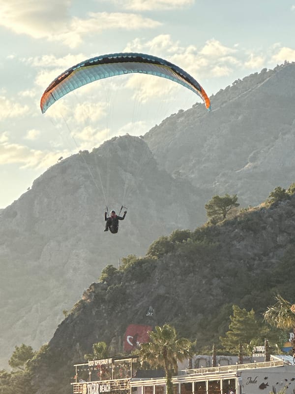 Paragliders active over crowded Fethiye boardwalks, Turkey