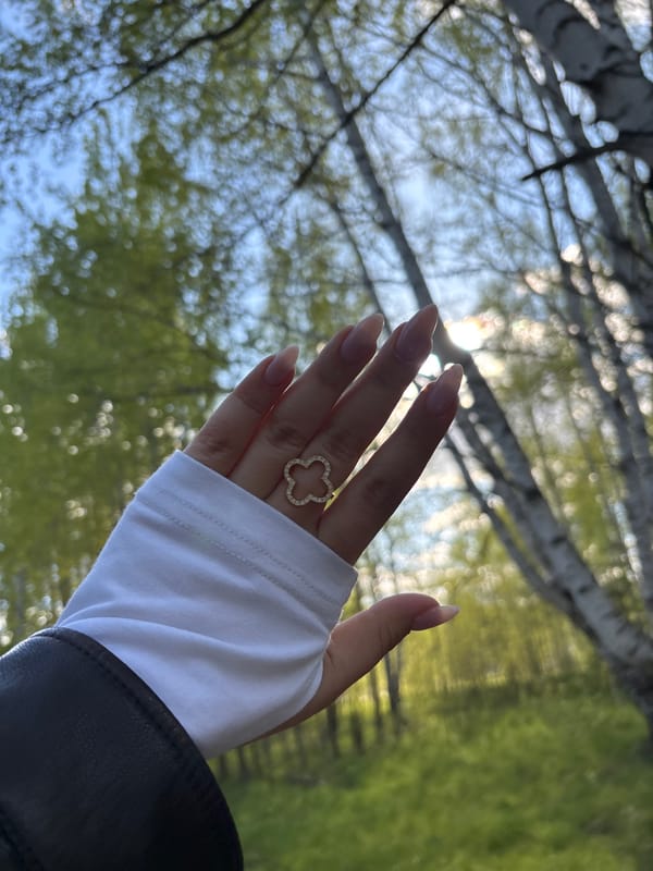 Woman with golden clover ring spotted amid birch trees