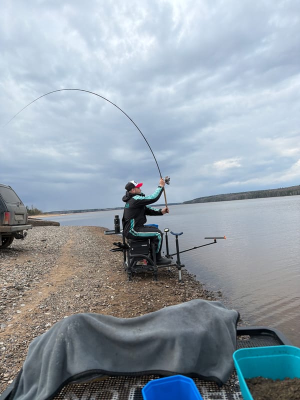 Angler fishes in rain along Chaikovsky waterway