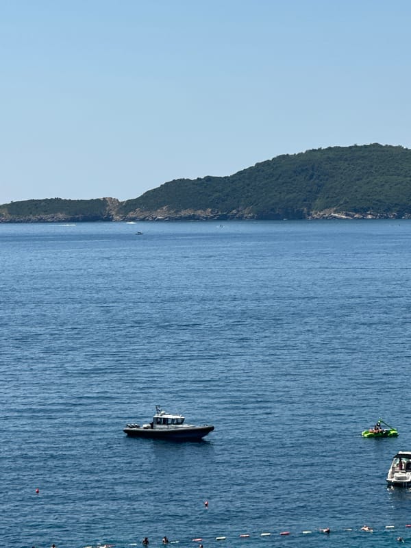 Crowded beach day at Kamenovo with parasailing over the Adriatic