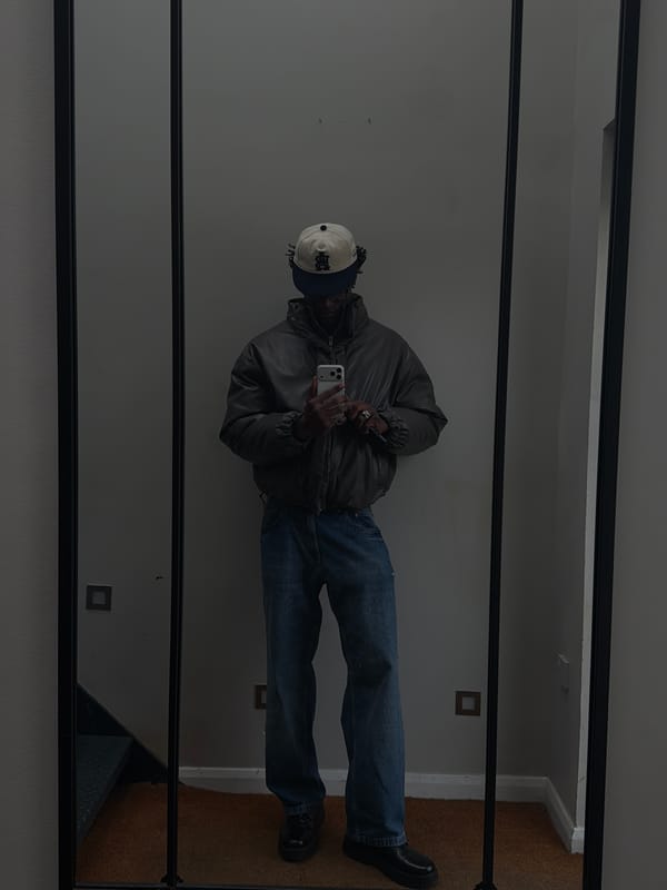 Person in layered winter clothing reflected in mirror, London