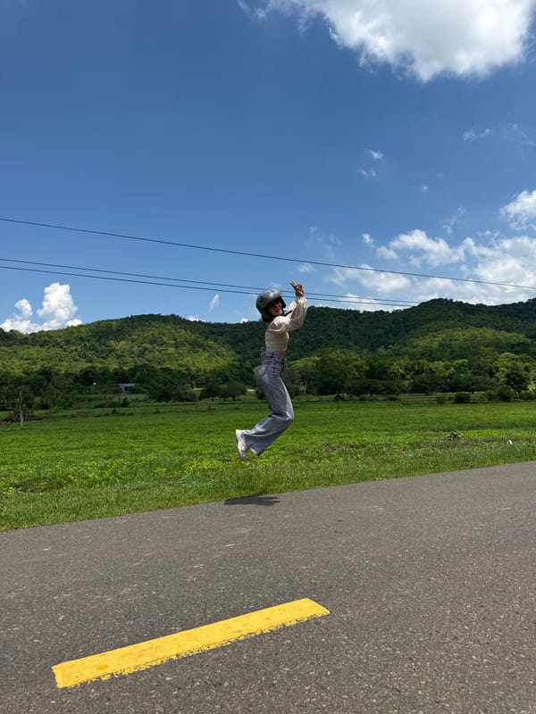 Woman poses and celebrates on scenic Vietnam road