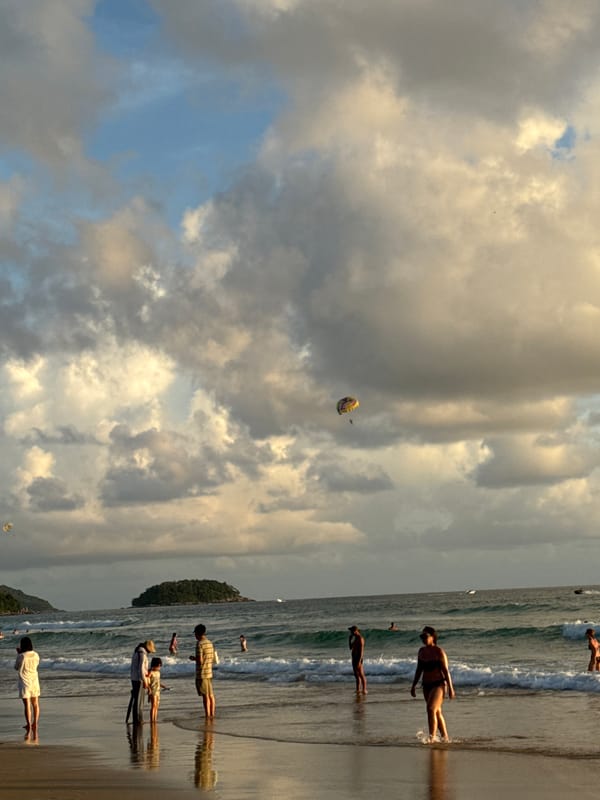 Karon Beach at sunset: waves, parasailing, and golden light