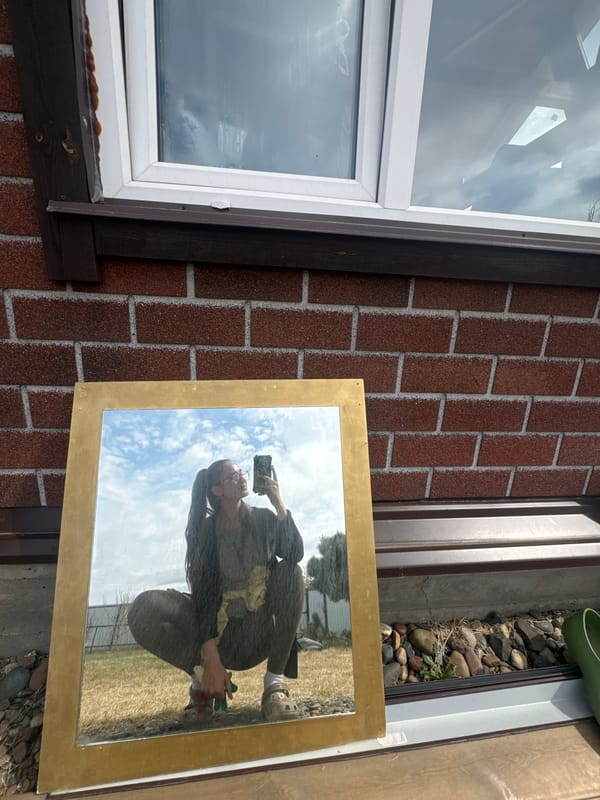 Person captures self-reflection while photographing gold-framed mirror in Russia