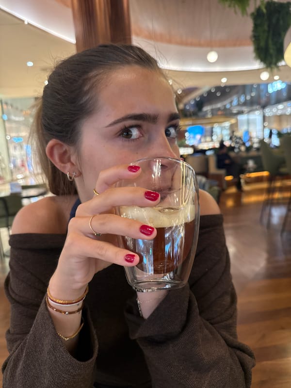 Woman enjoys layered drink at Matosinhos café