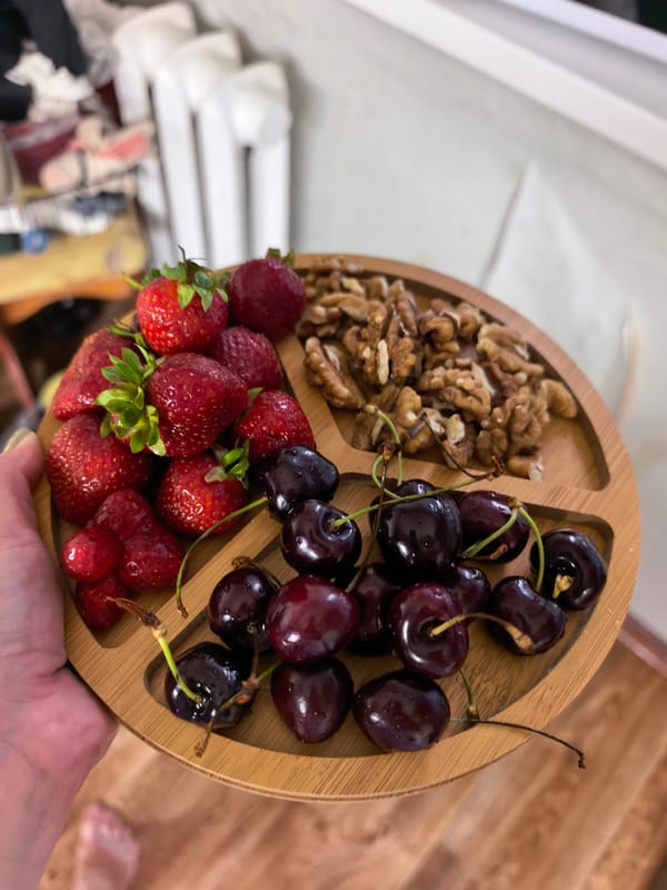 Three-section wooden platter with strawberries, cherries, and walnuts