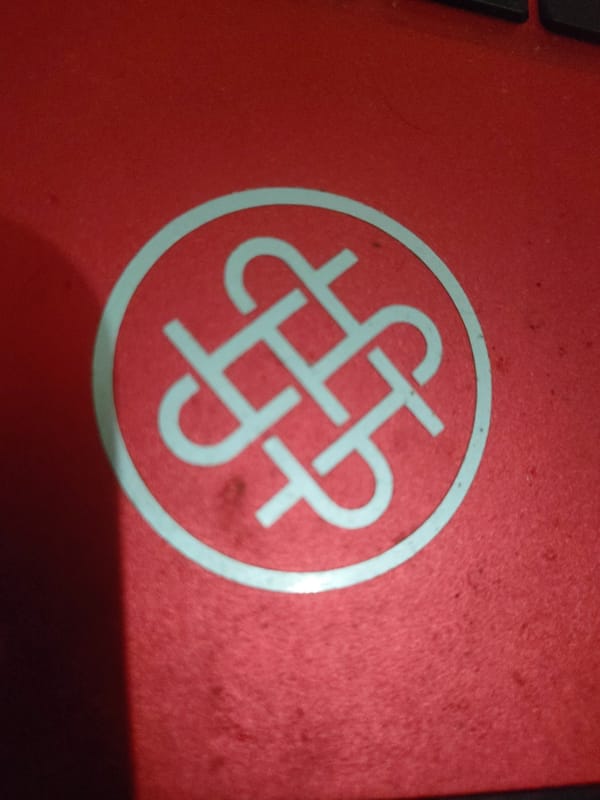 Close-up details: logo on red surface, rubber band on wood