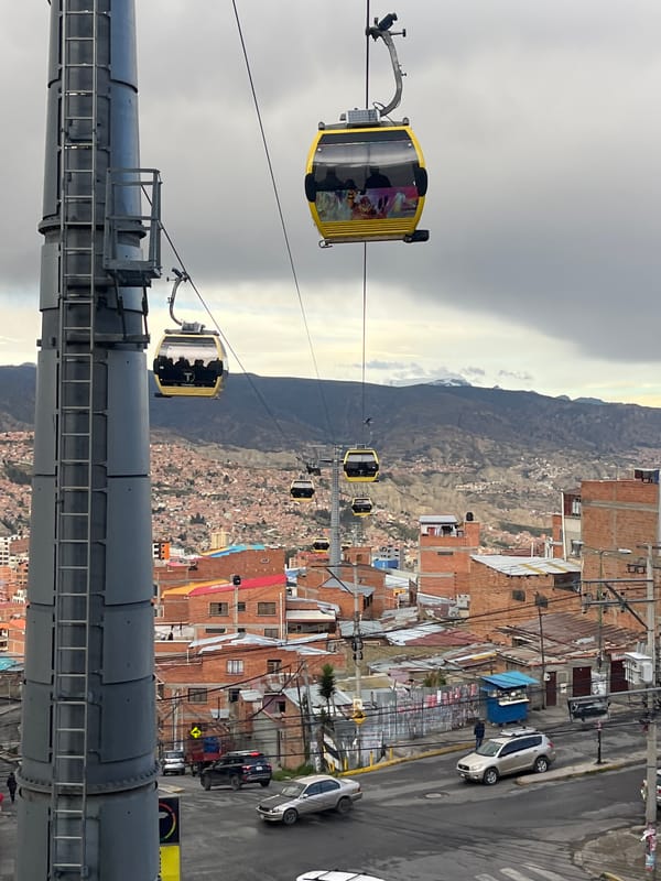 Cable car passengers observe La Paz cityscape from elevated stations