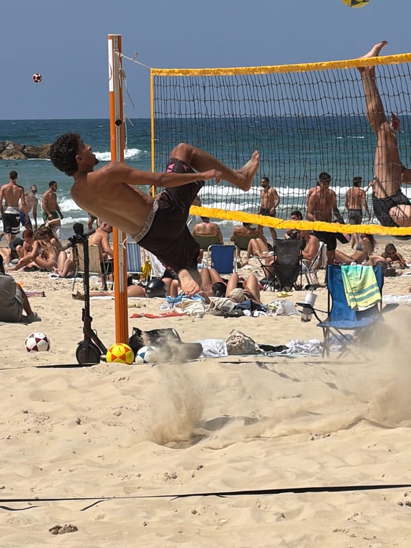 Sunny beach volleyball and sailing activity in Tel Aviv