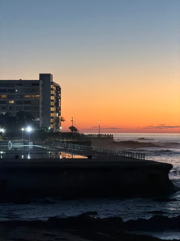Sunset observed over Cape Town waterfront with illuminated streetlights