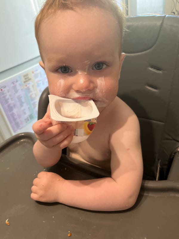 Woman with flowers, baby eating yogurt captured in Chaikovsky