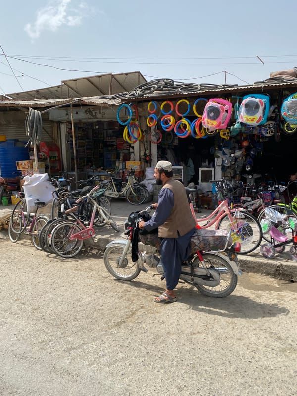 Street life outside a Kandahar bicycle shop, captured in motion