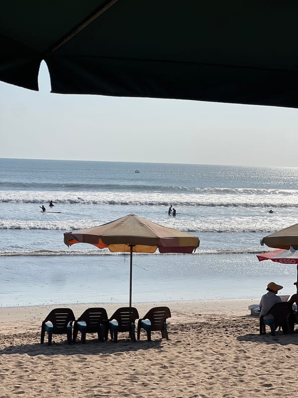 Busy morning at Kuta Beach — surfers, sand, and street life