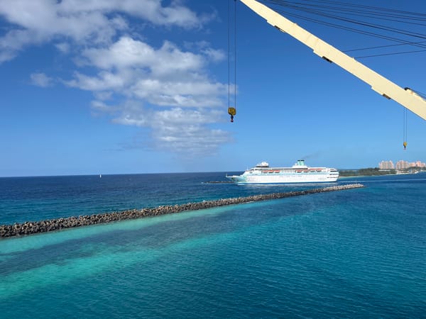 Cruise ship passes breakwater in turquoise waters