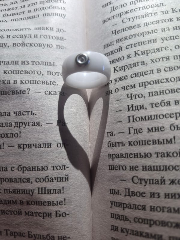 Ring casts heart-shaped shadow on Cyrillic text book