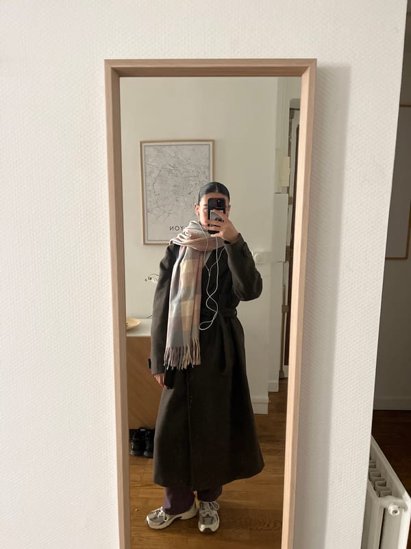 Person takes mirror selfie in Lyon apartment with map